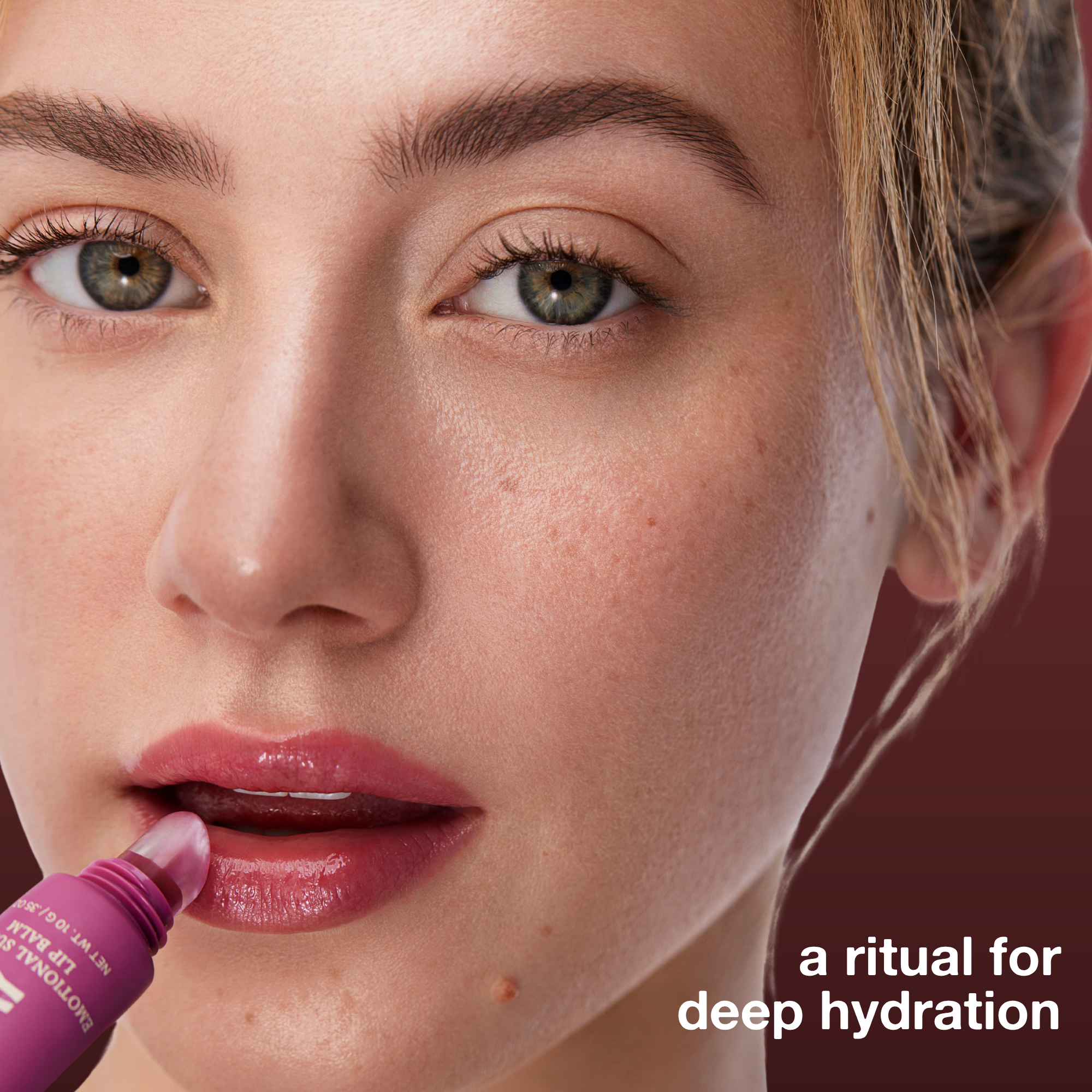 Close-up of a woman applying lip balm with text 'a ritual for deep hydration' on a dark background