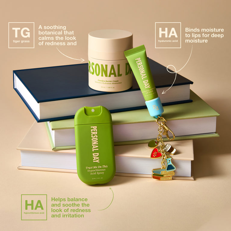 A styled product arrangement on a stack of books featuring three Personal Day skincare items: a white jar labeled Tiger Grass, a green tube labeled Hyaluronic Acid, and a green stick labeled Hyaluronic Acid, with decorative keychains and callout text boxes on a beige background.